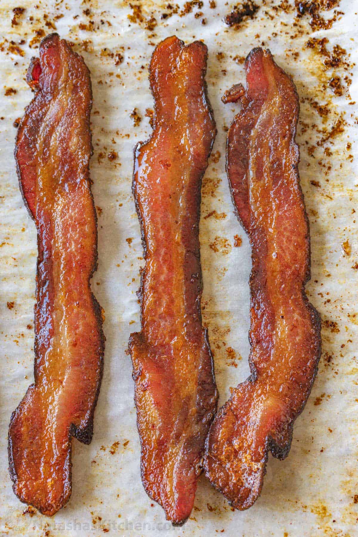 How to bake bacon in the oven that is perfectly crispy. Oven-baked bacon is the best for making a bigger batch and it's the easiest method. Perfectly cooked crispy strips of oven-baked bacon