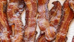 crispy oven-baked bacon on a plate lined with paper towel
