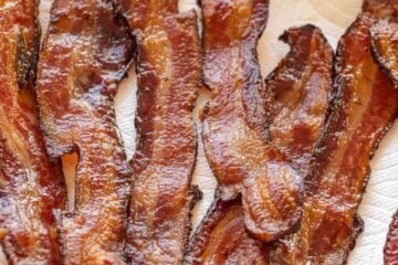 crispy oven-baked bacon on a plate lined with paper towel