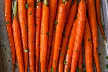 Roasted carrots on a baking sheet with garnish