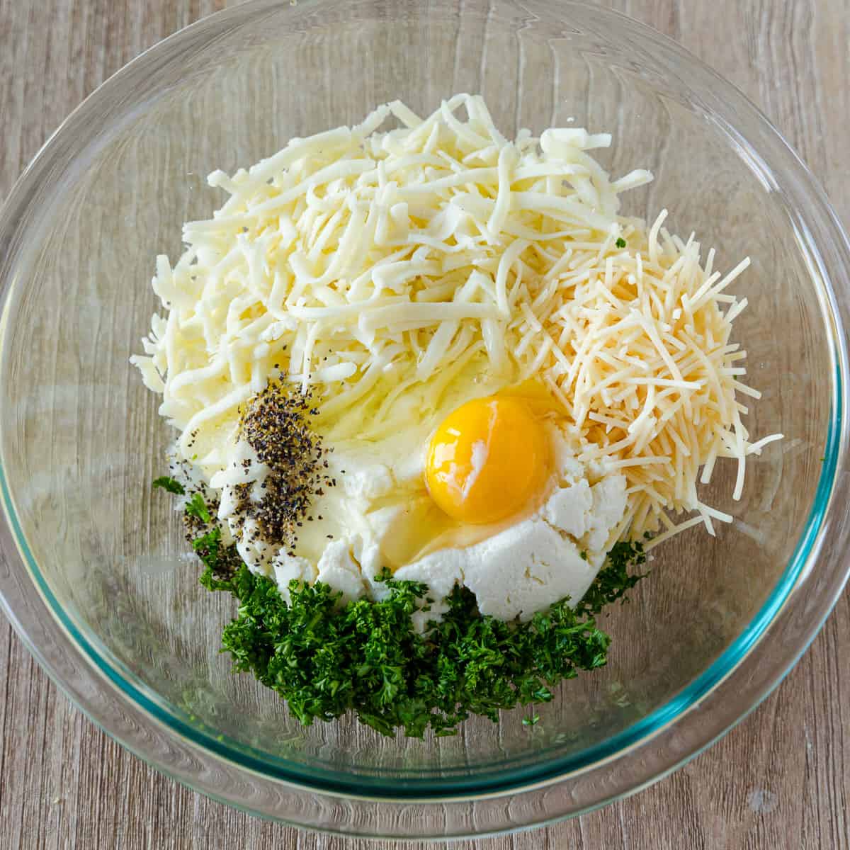 cheese egg and parsley in a bowl to be mixed