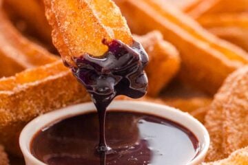Dipping churro in chocolate sauce