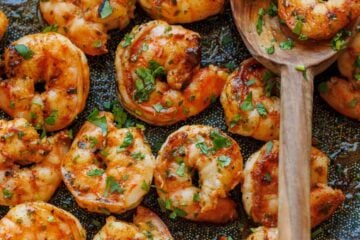 Grilled Cilantro Lime shrimp on a skillet with a wooden spoon