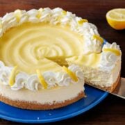 Lemon Cheesecake with lemon curd topping and whipped cream, sliced to remove the first piece