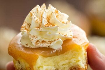 a mini cheesecake with a bite in a hand