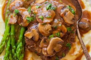 Salisbury steak dinner with mashed potatoes, asparagus and mushrooms
