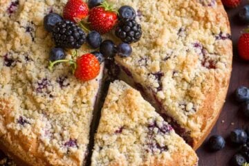 Berry Cake with 1 slice cut out garnished with mixed berries