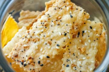 Sourdough Discard Crackers seasoned with salt and sesame seeds and baked to golden perfection in a glass jar for storage.