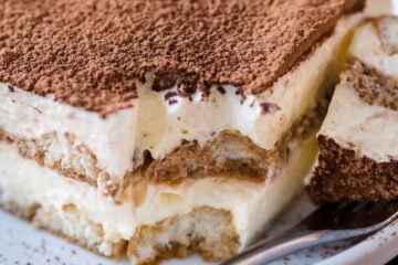 Tiramisu cake slice on a plate with a fork