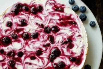 beautiful no-bake Blueberry Cheesecake on a white plate with blueberry topping
