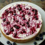 no-bake blueberry cheesecake on a white plate with fresh blueberries