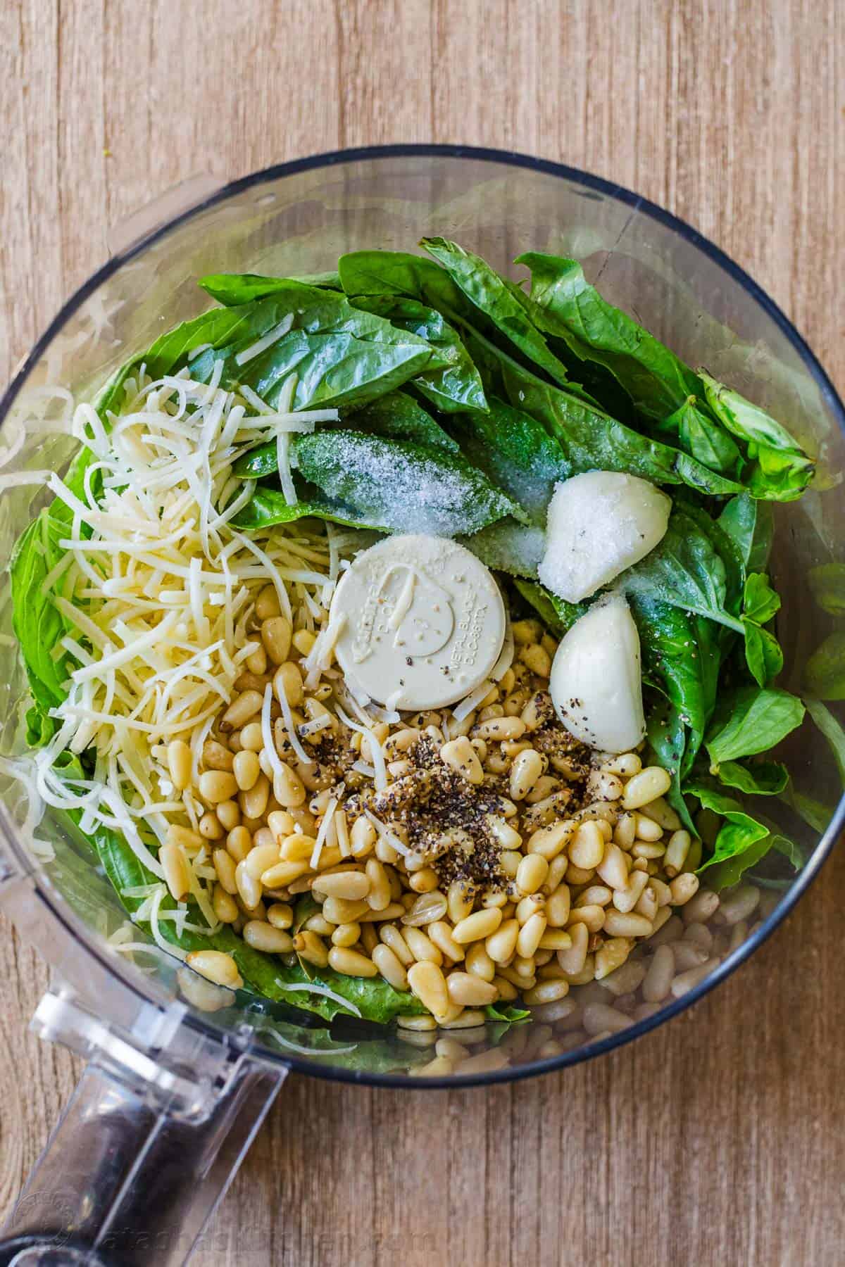 Ingredients for basil pesto sauce in a food processor.