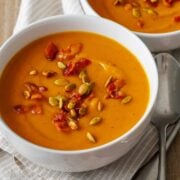 pumpkin soup recipe with pepitas and bacon bits sprinkled on top