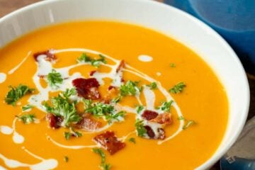 Creamy sweet potato soup in bowl garnished with coconut milk