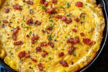 Potato Crust Quiche in a well-seasoned 10-inch cast iron skillet, topped with bacon and parsley