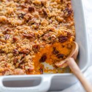 Sweet potato casserole with crunchy pecan topping in a casserole dish.