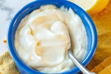 Creamy Homemade Mayonnaise in a blue ramekin with a spoon.