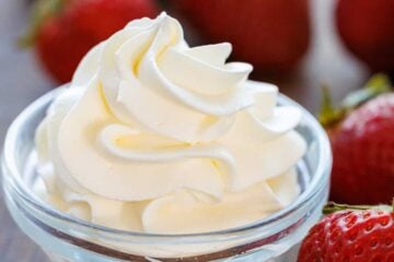 homemade whipped dream piped into a small bowl with strawberries for dipping