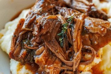 classic pot roast recipe served over mashed potatoes in a white bowl