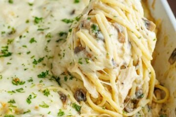A fork scooping chicken tetrazzini recipe out of a serving dish