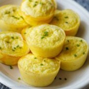 Cottage cheese egg bites recipe on a white plate with chives sprinkled on top