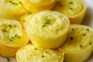 Cottage Cheese egg bites recipe stacked on a white plate with chives on top