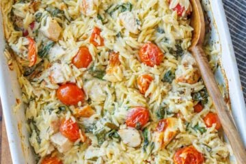 Creamy chicken pasta casserole with cherry tomatoes in a white casserole dish