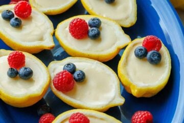 lemon posset recipe served on a blue dish with berry garnish