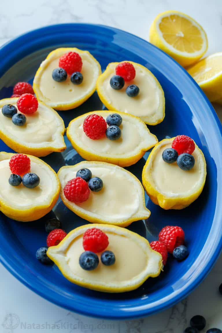 lemon posset recipe served on a blue dish with berry garnish