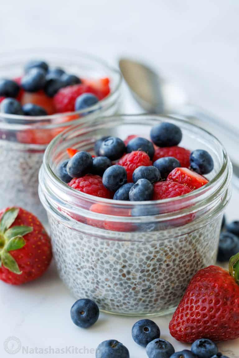 Simple chia seed pudding recipe in mason jars with berries on top