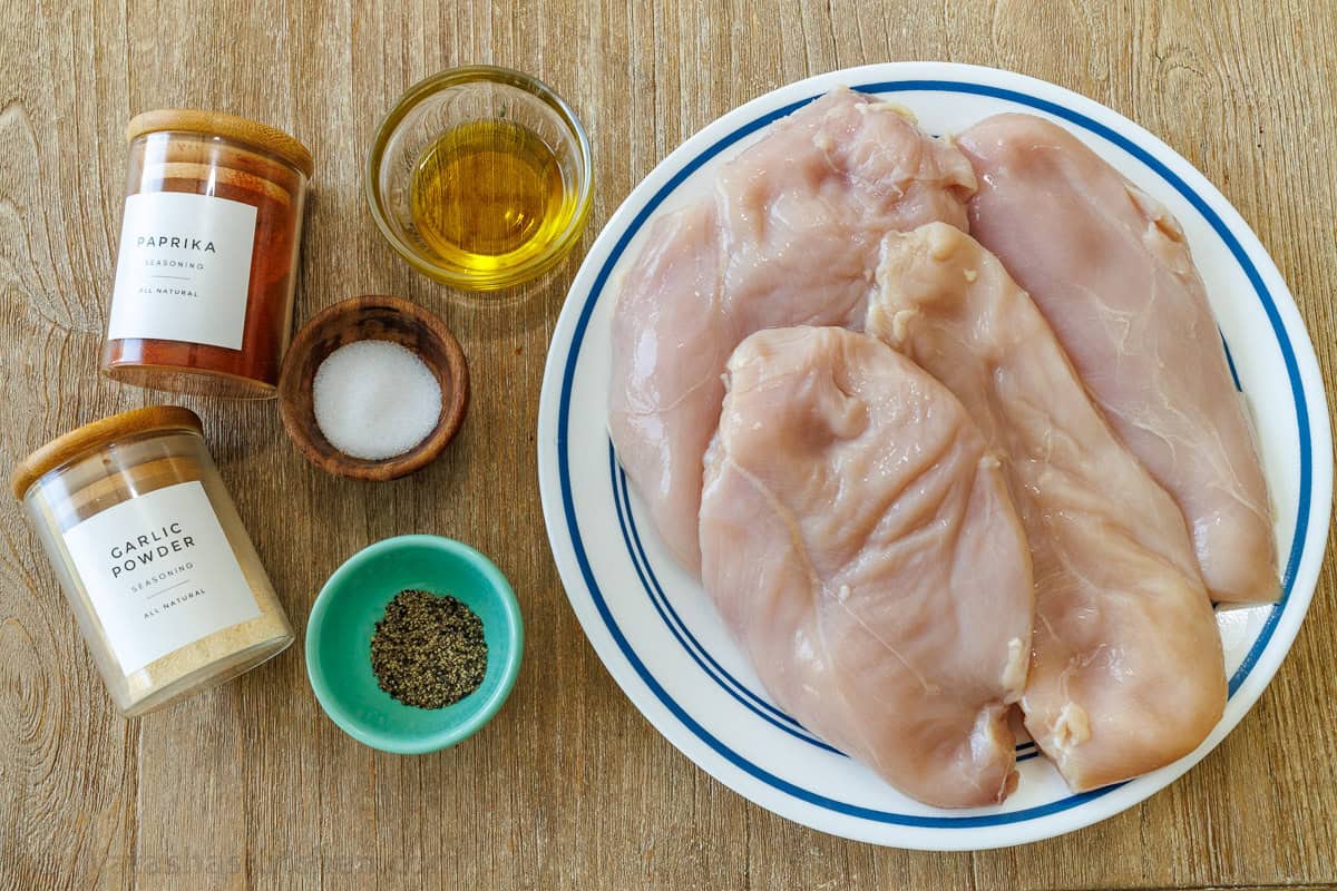Ingredients for baked chicken breasts with seasonings and oil