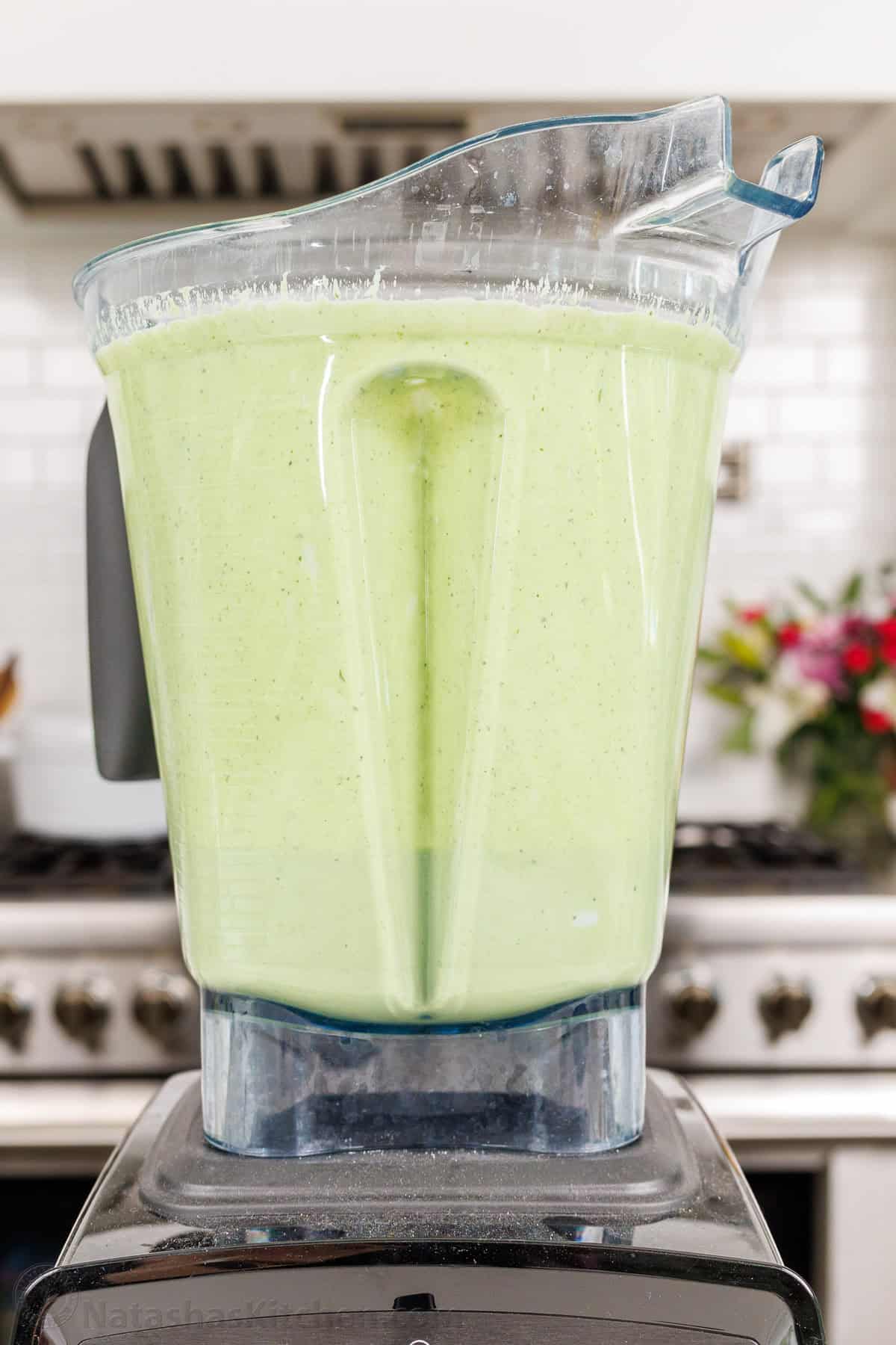 Homemade Green Goddess Dressing is easy to make and tastes so fresh and vibrant. It takes just 30 seconds from blender to topping salads! Green Goddess dressing mixed in a blender in a white kitchen