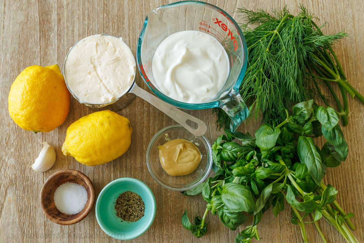 Homemade Green Goddess Dressing is easy to make and tastes so fresh and vibrant. It takes just 30 seconds from blender to topping salads! Ingredients for Green Goddess Dressing including lemon, garlic, Greek yogurt, Mayo, Dijon mustard, salt, pepper, basil and dill