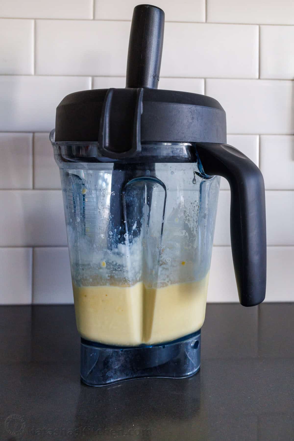 Blender with a tamper accessory blending yellow mixture