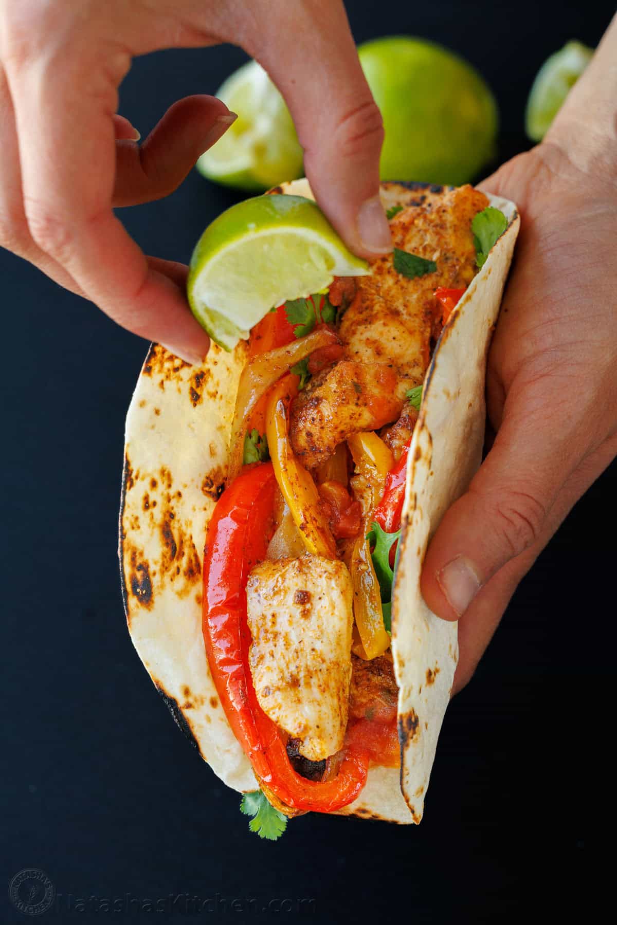 Sheet Pan Chicken Fajitas recipe packed with flavor. It's a crowd-pleasing, 30-minute, one pan meal that makes any weeknight meal a fiesta! Drizzling lime on a fajita in a tortilla