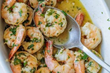 Shrimp scampi recipe in a white dish with butter garlic sauce and parsley garnish