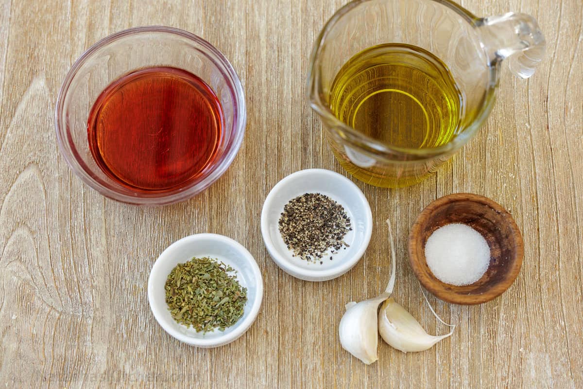 ingredients for Greek Salad dressing recipe including red wine vinegar, oil, salt, pepper, oregano, salt and garlic