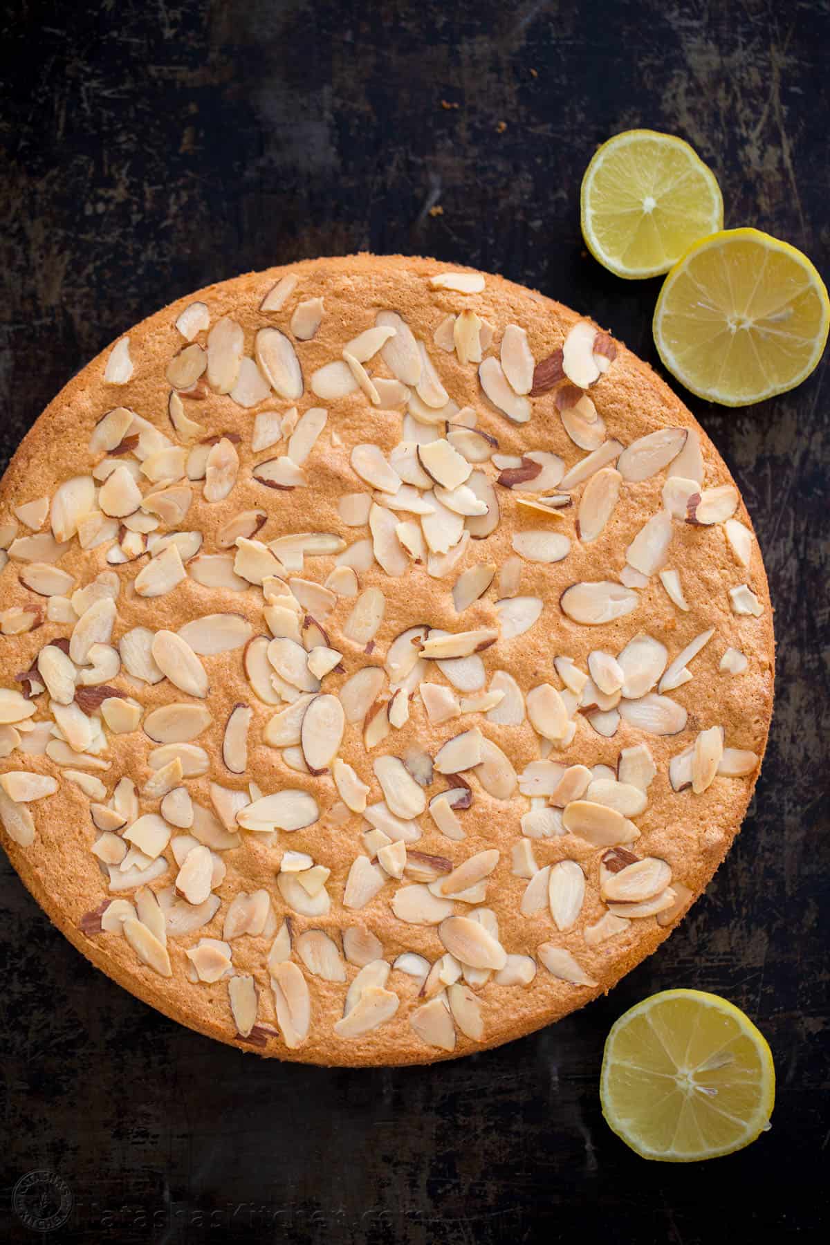 Almond cake with sliced almonds and citrus garnish
