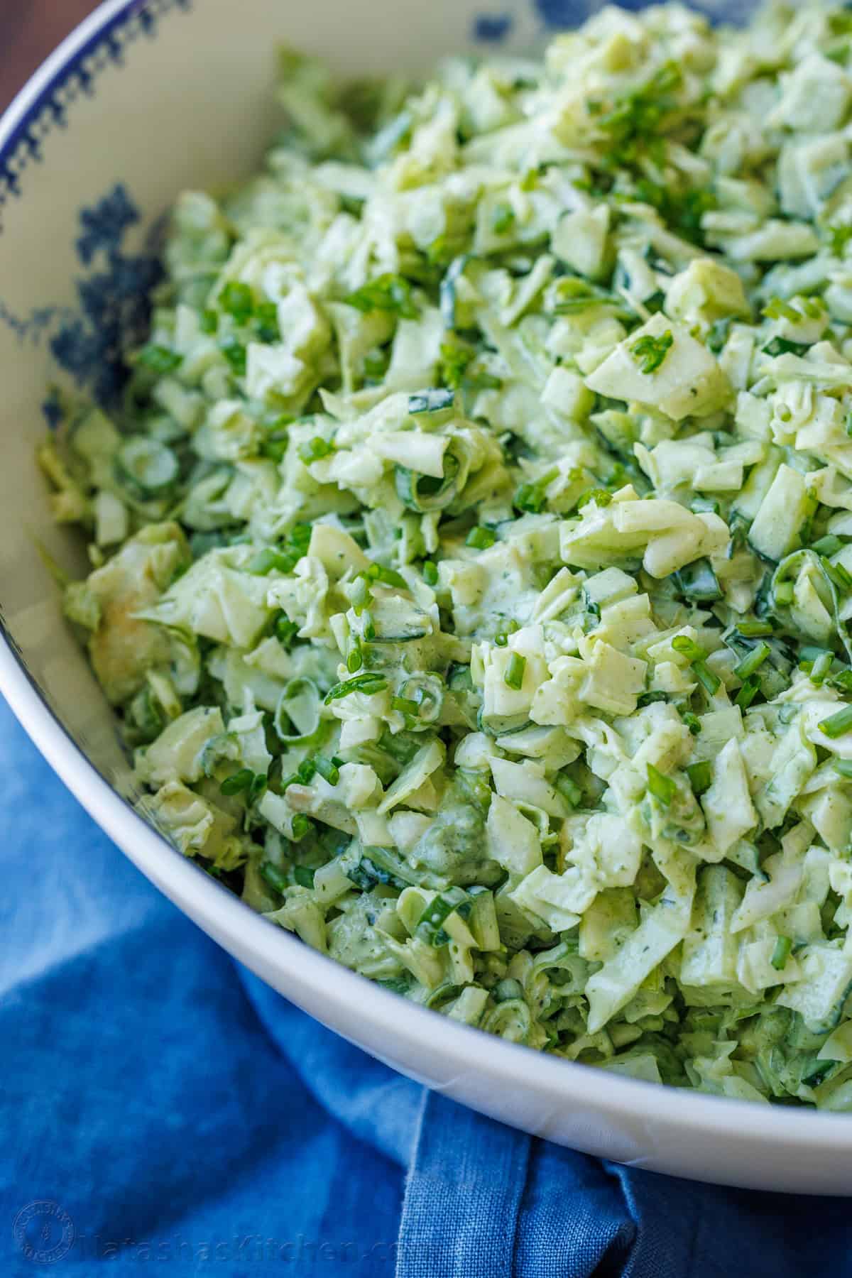 This easy Green Goddess Salad recipe comes together in minutes for the perfect side dish or lunch. Eat with a tortilla chip for a fun twist! Chopped cabbage in a bowl with homemade dressing