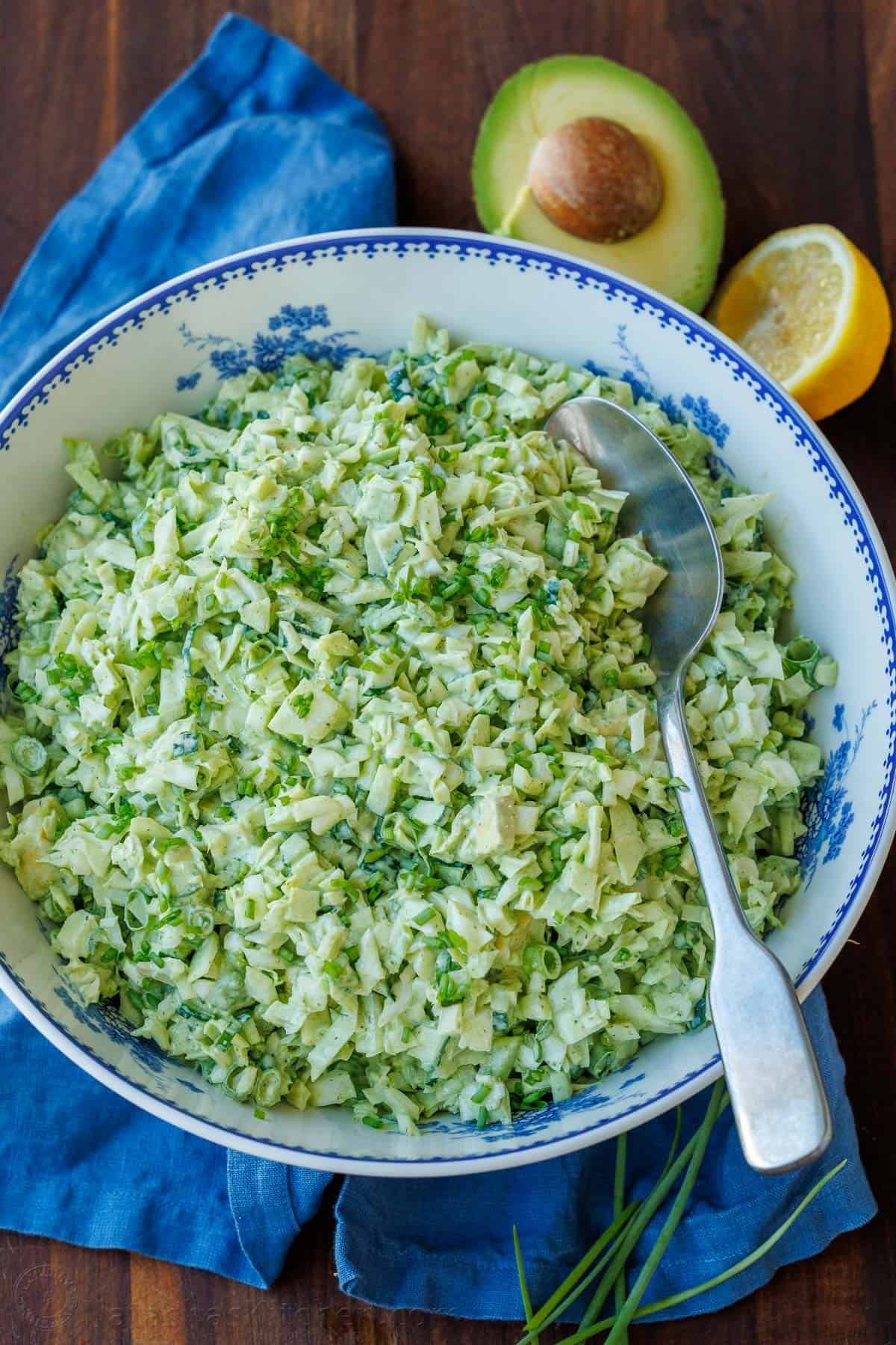 This easy Green Goddess Salad recipe comes together in minutes for the perfect side dish or lunch. Eat with a tortilla chip for a fun twist! Green Goddess chopped salad in a bowl with avocado slices and a spoon