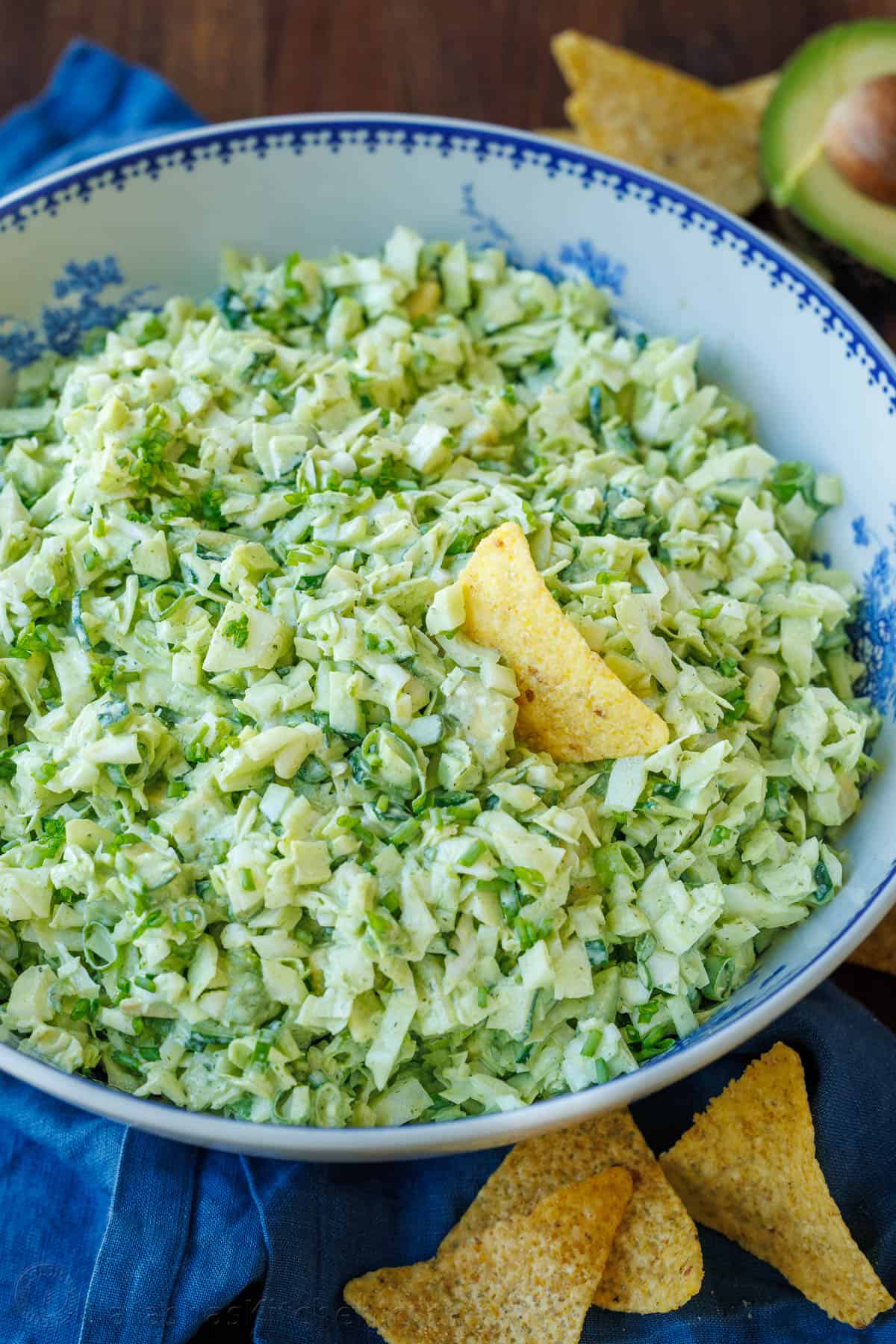 This easy Green Goddess Salad recipe comes together in minutes for the perfect side dish or lunch. Eat with a tortilla chip for a fun twist! Green Goddess Salad in a bowl with corn chips around