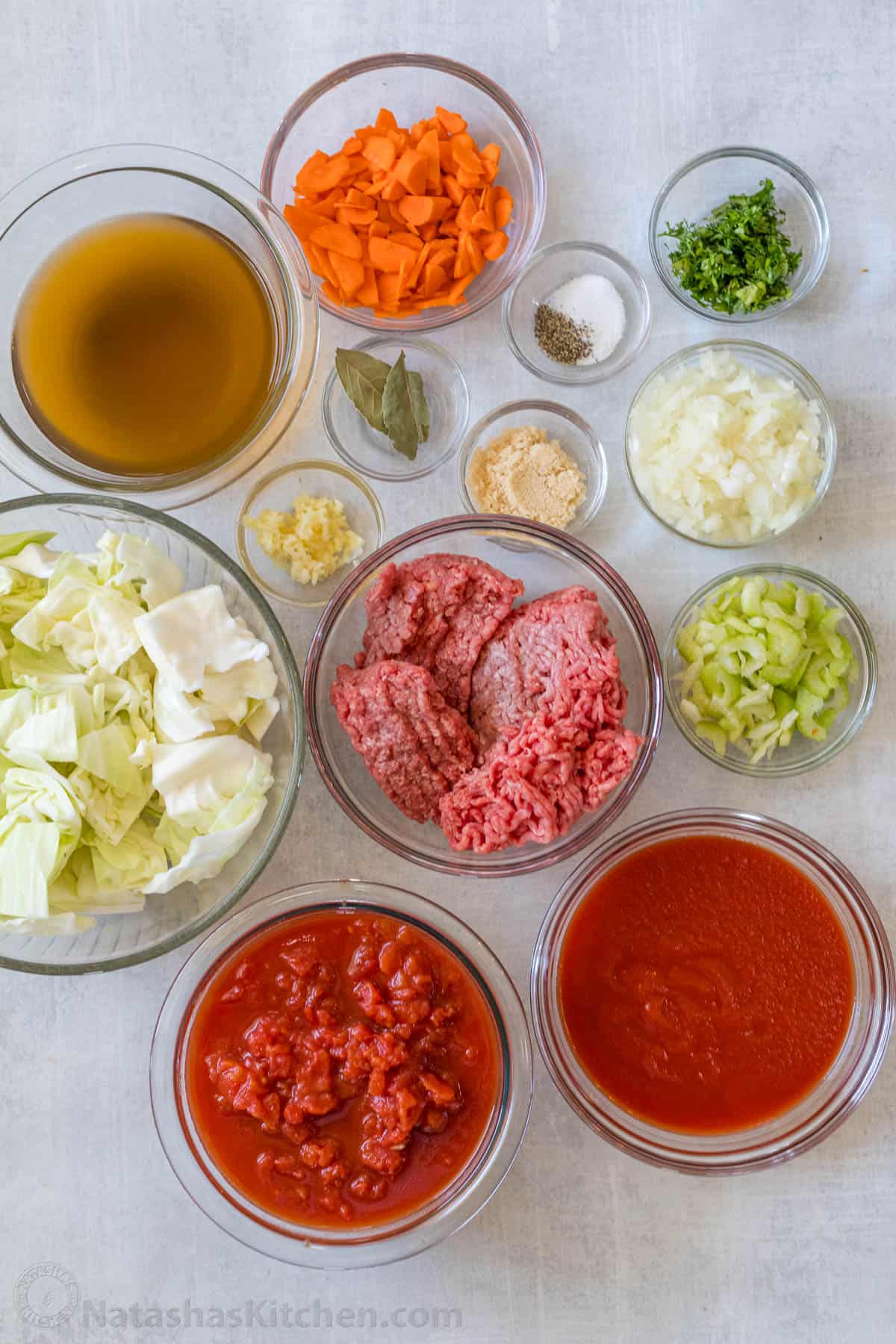 My homemade Cabbage Soup recipe is so easy to make and tastes as good as my Cabbage rolls without the hassle! Filling & Freezer-friendly. Ingredients for Fall stew using ground beef, oil, onion, garlic, carrot, celery, greens, diced tomatoes, tomato sauce, beef broth, brown sugar, bay leaves and chopped herbs