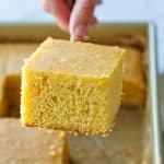 Serving a square of homemade cornbread from a square pan