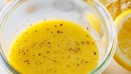 Lemon vinaigrette dressing recipe with garlic, pepper, lemon slices and honey
