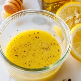 Lemon vinaigrette dressing recipe with garlic, pepper, lemon slices and honey
