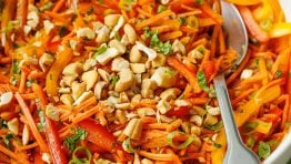 Spicy Korean Carrot Salad recipe with a spoon garnished with cashew nuts