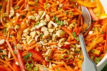 Spicy Korean Carrot Salad recipe with a spoon garnished with cashew nuts