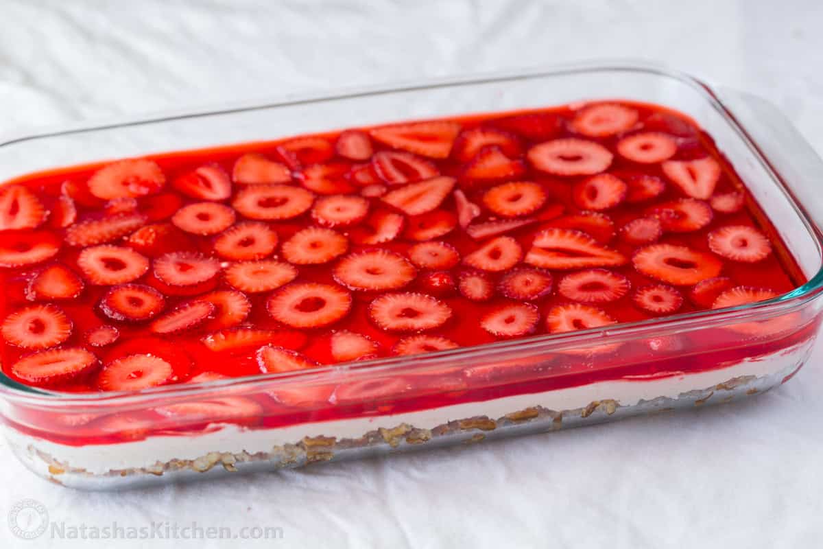 Easy Strawberry Pretzel Salad is a crowd-favorite dessert recipe at parties and picnics! Easy make-ahead directions everyone will love! Strawberry Pretzel salad in a clear casserole dish with strawberry jello layer on top