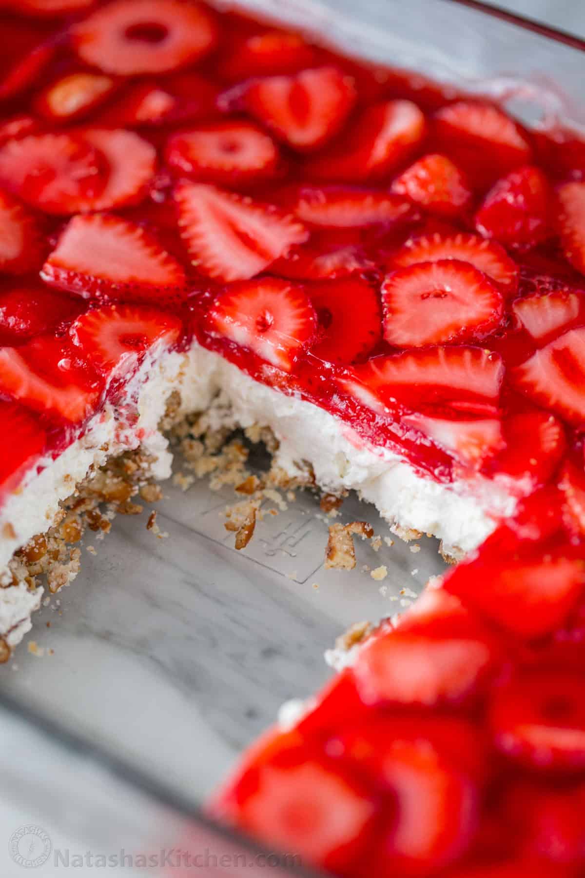 Easy Strawberry Pretzel Salad is a crowd-favorite dessert recipe at parties and picnics! Easy make-ahead directions everyone will love! A slice cut out of a dish of strawberry pretzel salad