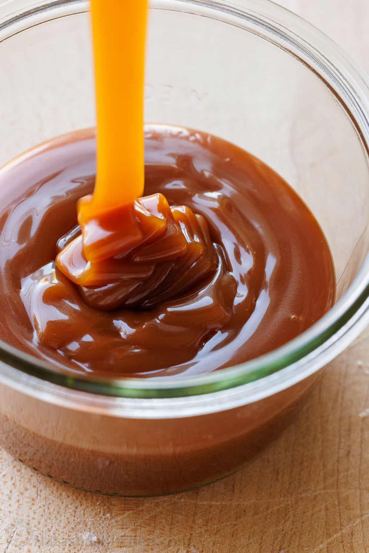 Homemade caramel sauce drizzled into a clear jar